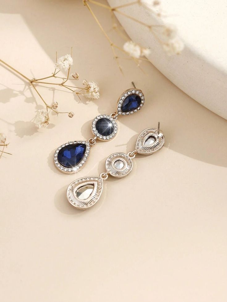 A pair of stylish, modern, bohemian-style earrings made of metal, glass, and rhinestone.