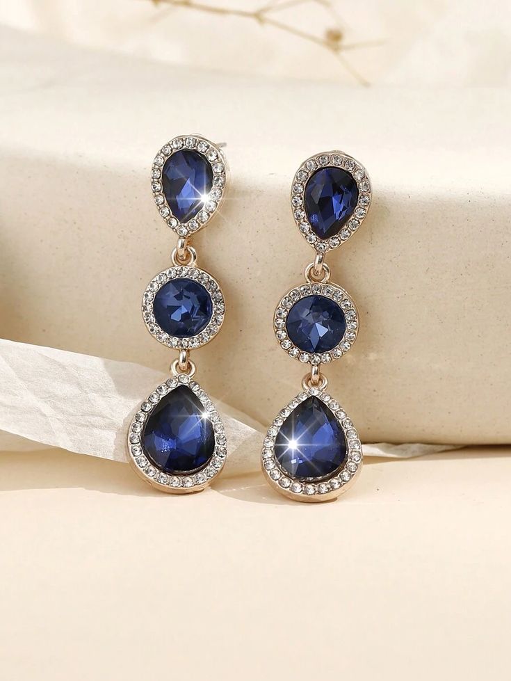 A pair of stylish, modern, bohemian-style earrings made of metal, glass, and rhinestone.