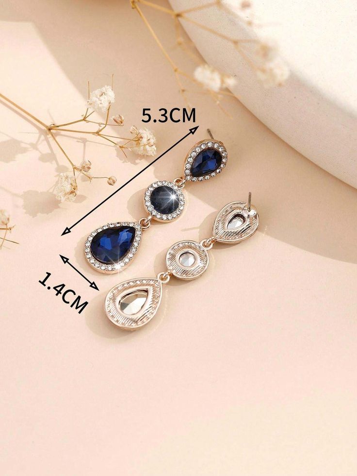 A pair of stylish, modern, bohemian-style earrings made of metal, glass, and rhinestone.